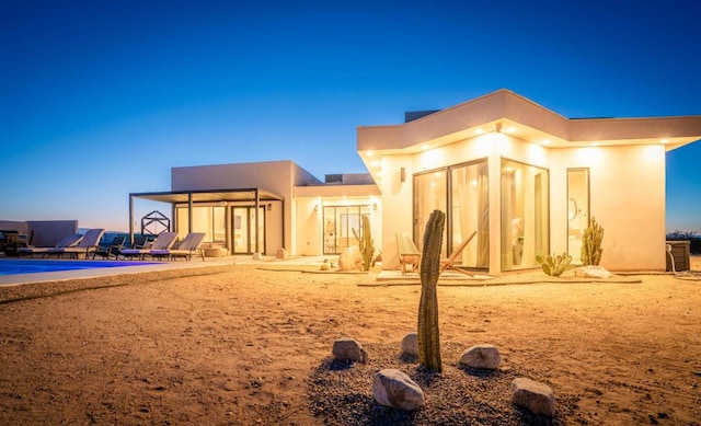 back house at dusk with a patio area