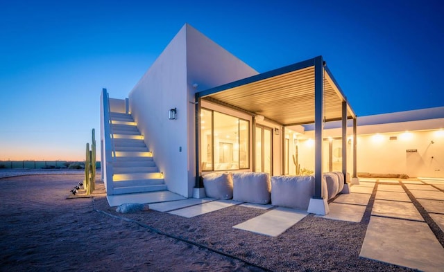 back house at dusk featuring a water view