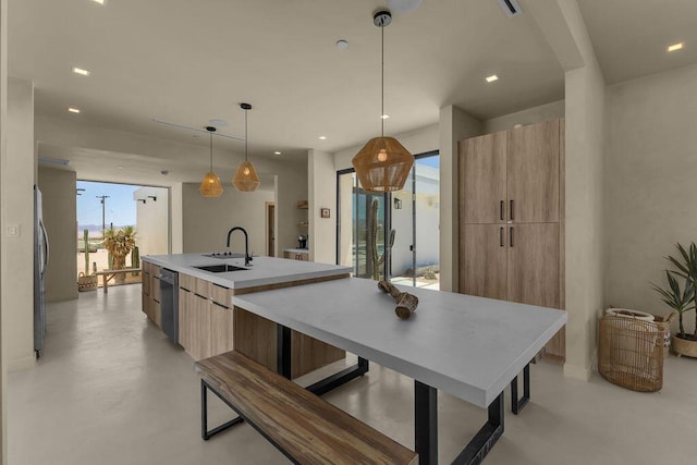 kitchen featuring sink, an island with sink, decorative light fixtures, and appliances with stainless steel finishes