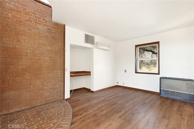 interior space featuring heating unit, dark hardwood / wood-style floors, and a wall mounted air conditioner