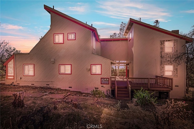 back house at dusk with a deck