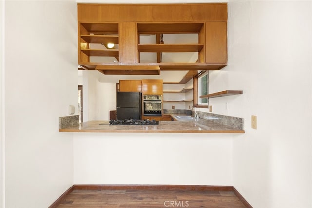 kitchen with sink, dark wood-type flooring, and black appliances