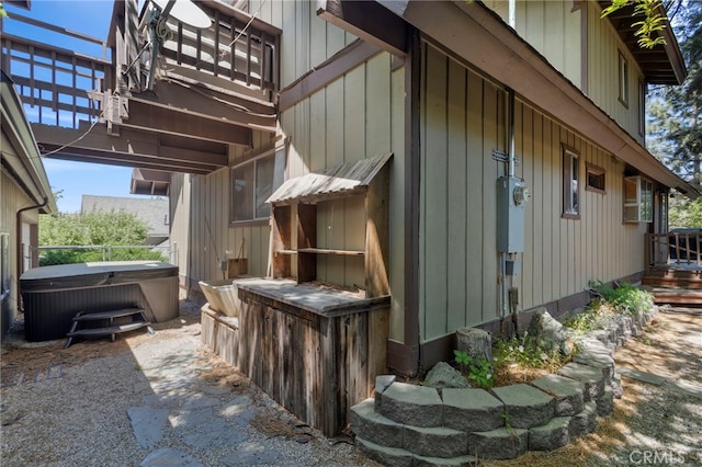 view of property exterior with a hot tub and cooling unit