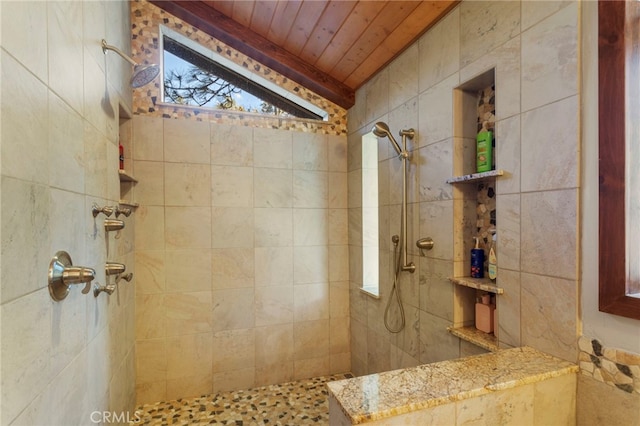 bathroom with a tile shower, lofted ceiling, and wooden ceiling