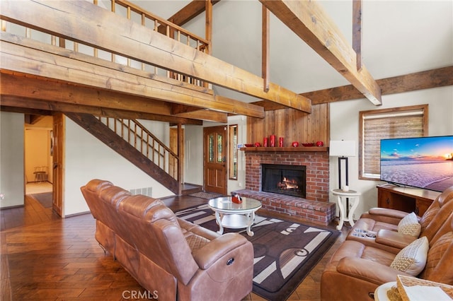 living room with a fireplace, a high ceiling, dark wood-type flooring, and beam ceiling