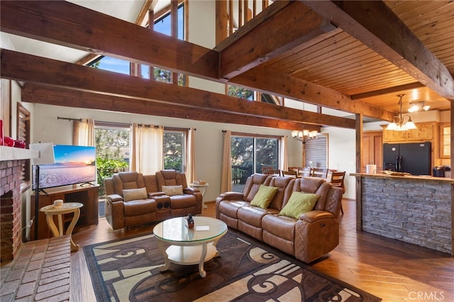 living room with high vaulted ceiling, an inviting chandelier, a brick fireplace, beam ceiling, and wood-type flooring