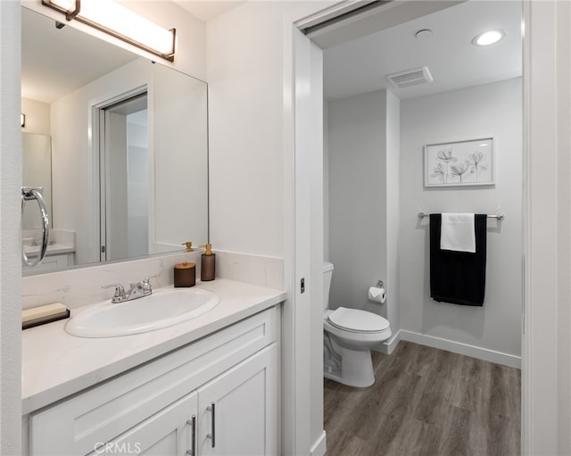 bathroom with hardwood / wood-style flooring, vanity, and toilet