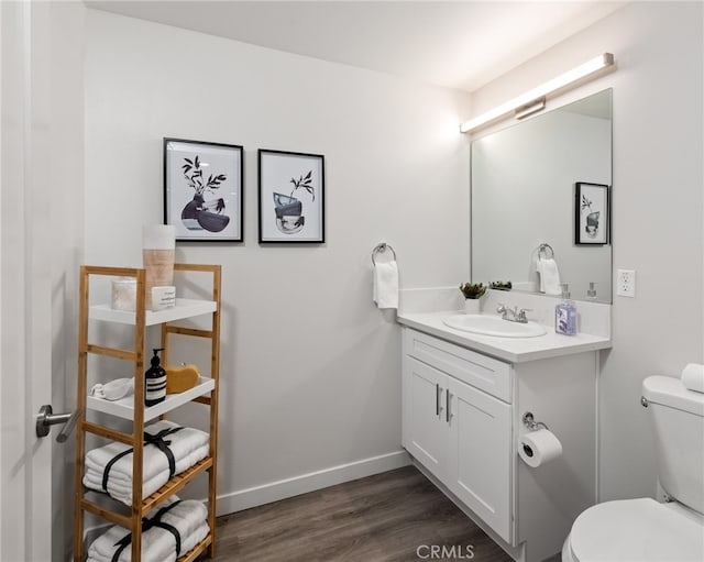 bathroom with vanity with extensive cabinet space, toilet, and hardwood / wood-style flooring