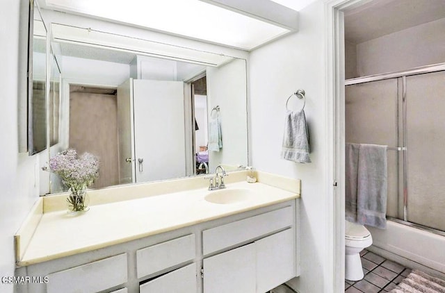 full bathroom with tile patterned flooring, vanity, toilet, and bath / shower combo with glass door