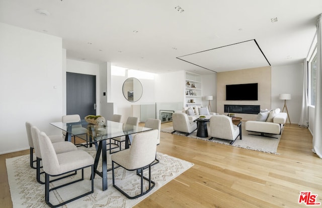 dining area with light wood-type flooring and built in features