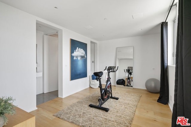 workout area with light hardwood / wood-style floors