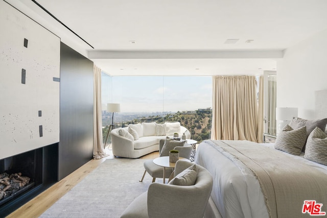 bedroom with hardwood / wood-style floors and floor to ceiling windows