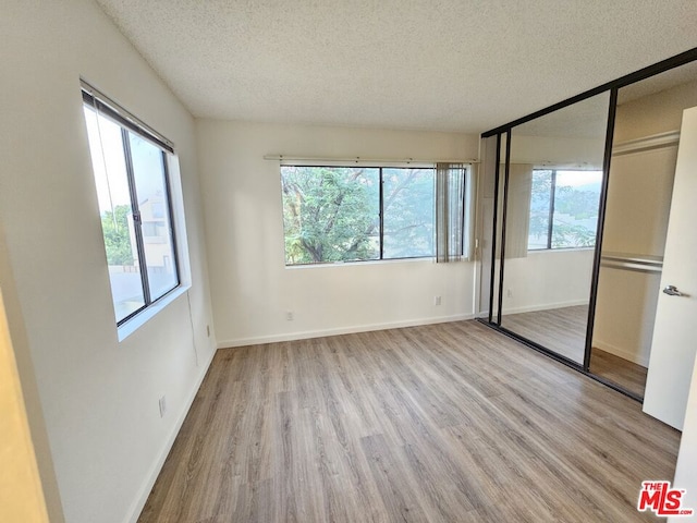 unfurnished bedroom featuring light hardwood / wood-style floors and multiple windows