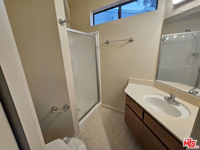 bathroom featuring an enclosed shower, tile flooring, and oversized vanity