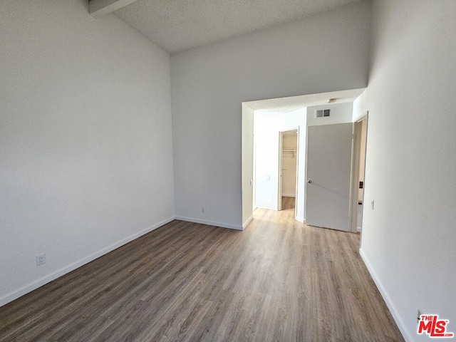 spare room with beamed ceiling and hardwood / wood-style floors