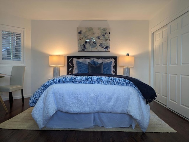 bedroom with dark hardwood / wood-style floors and a closet