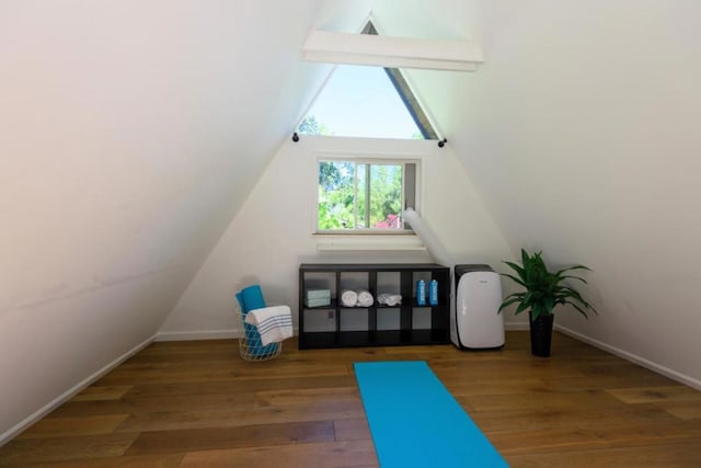 bonus room with dark wood-type flooring and vaulted ceiling