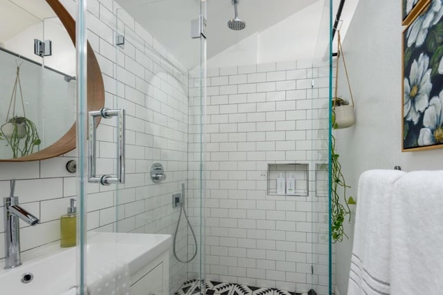 bathroom with sink and a shower with door