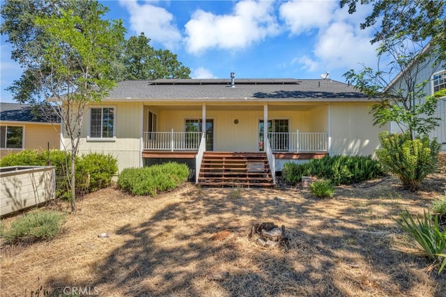 view of front of house with covered porch and solar panels