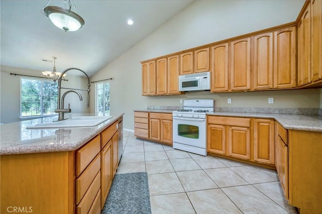 kitchen featuring white appliances, vaulted ceiling, decorative light fixtures, a chandelier, and an island with sink