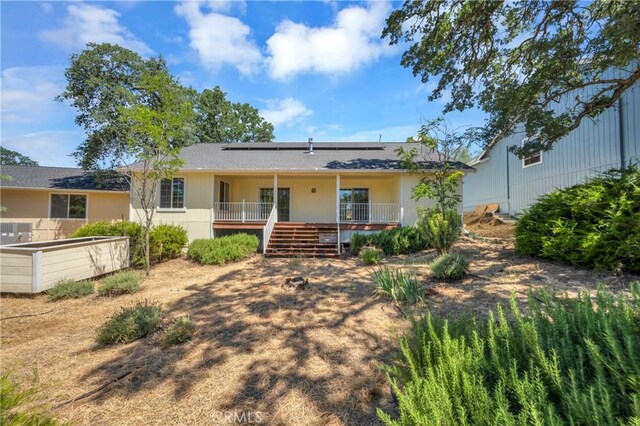 view of front of home with covered porch and solar panels