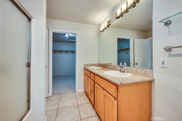 bathroom with tile patterned flooring, vanity, and a shower with shower door