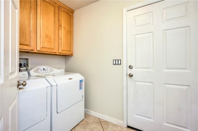 washroom featuring cabinets, light tile patterned floors, and washing machine and dryer