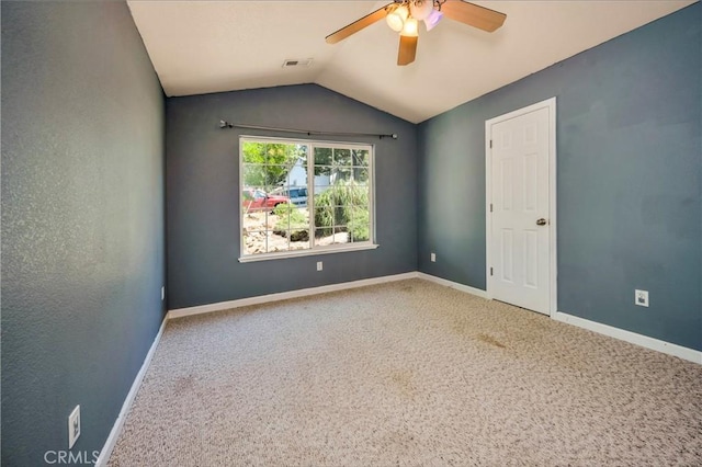 carpeted spare room with ceiling fan and lofted ceiling