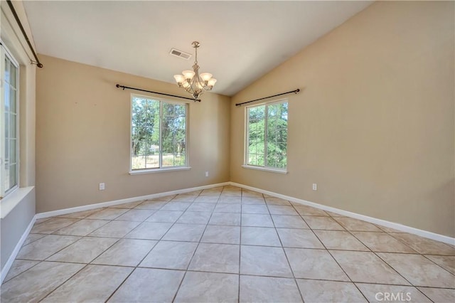 empty room featuring a chandelier, light tile patterned floors, and vaulted ceiling