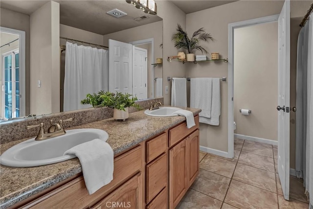 bathroom featuring vanity, tile patterned flooring, and toilet