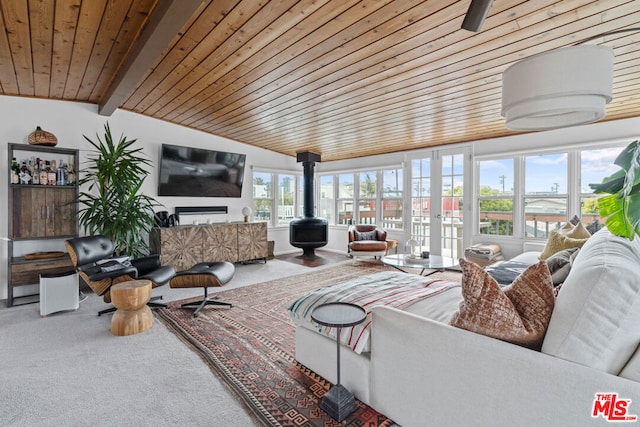 carpeted living room with wood ceiling, a wood stove, and vaulted ceiling with beams