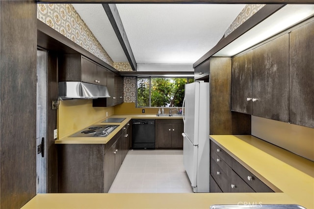 kitchen featuring dark brown cabinets, black appliances, range hood, and sink