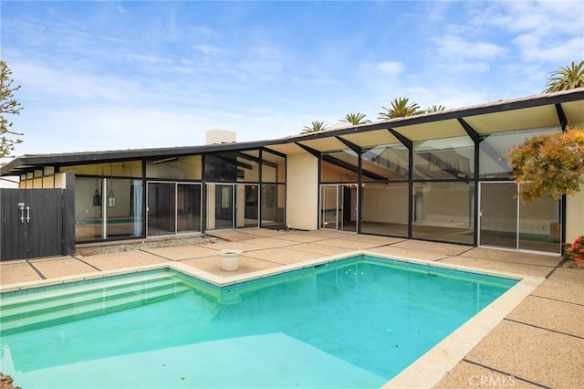 view of pool featuring glass enclosure and a patio area