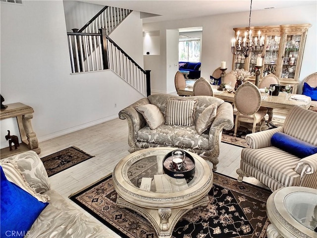 living room with light hardwood / wood-style floors and a notable chandelier