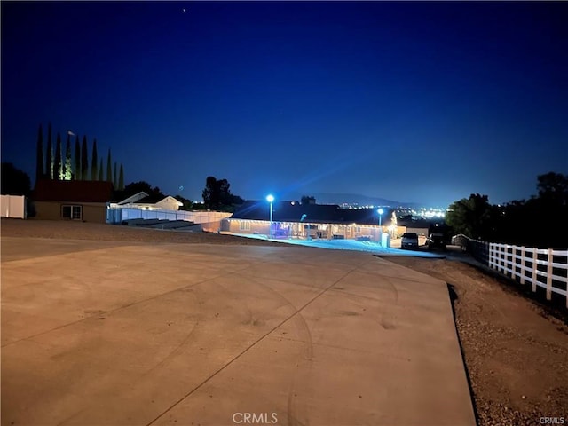 yard at night featuring a community pool