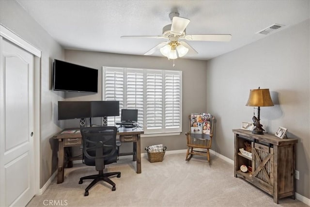 carpeted office space featuring ceiling fan