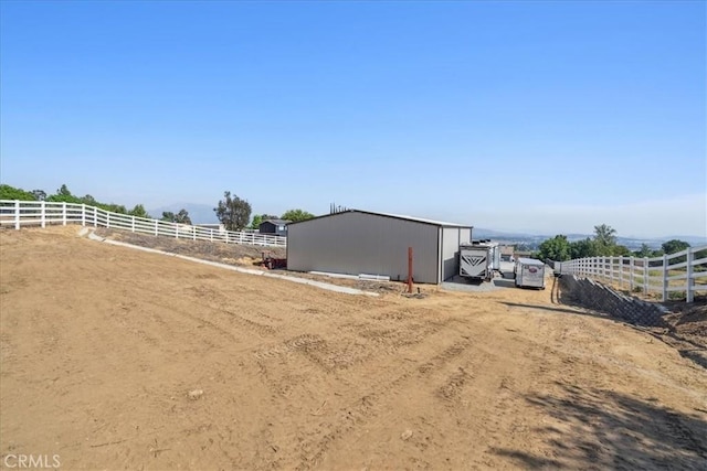 view of yard with a rural view and an outdoor structure