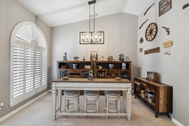 dining area with a chandelier, light colored carpet, and lofted ceiling