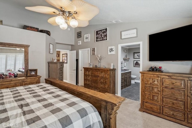 carpeted bedroom featuring ensuite bath, ceiling fan, and lofted ceiling