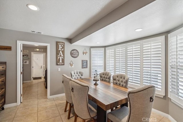 tiled dining room with a textured ceiling