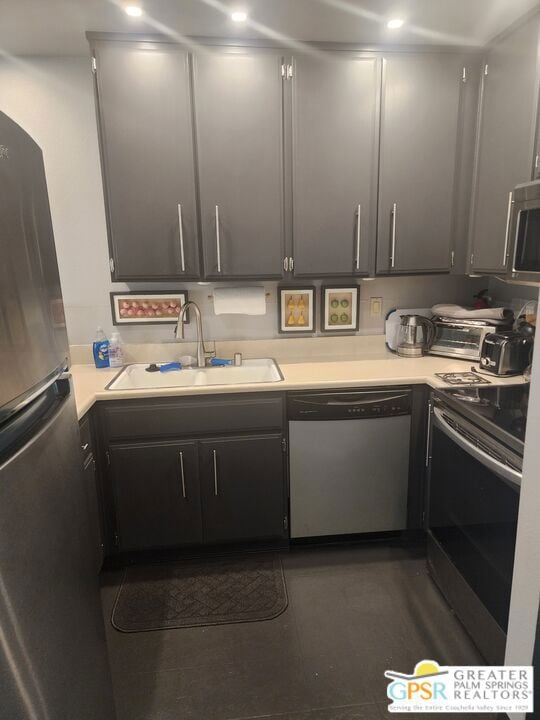 kitchen with gray cabinets, sink, and appliances with stainless steel finishes