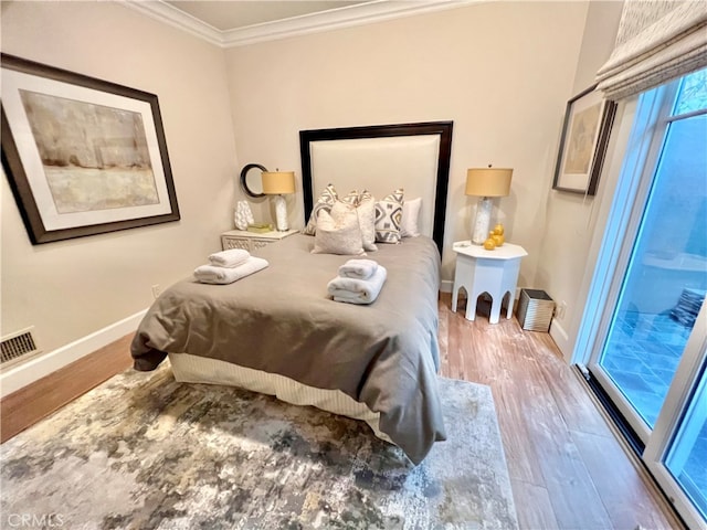 bedroom featuring access to exterior, crown molding, and hardwood / wood-style floors