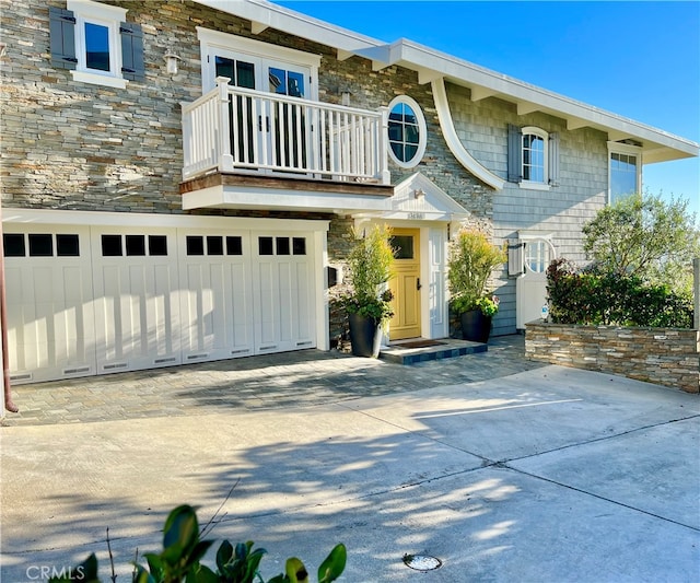 view of front of home with a garage and a balcony