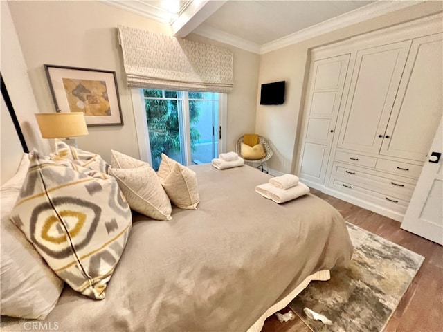 bedroom with beam ceiling, crown molding, and hardwood / wood-style floors