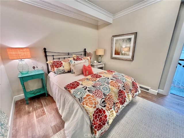 bedroom featuring crown molding and hardwood / wood-style floors