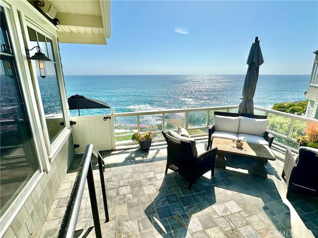 balcony featuring an outdoor living space and a water view