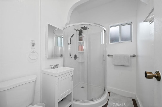 full bath featuring plenty of natural light, vanity, a shower stall, and toilet
