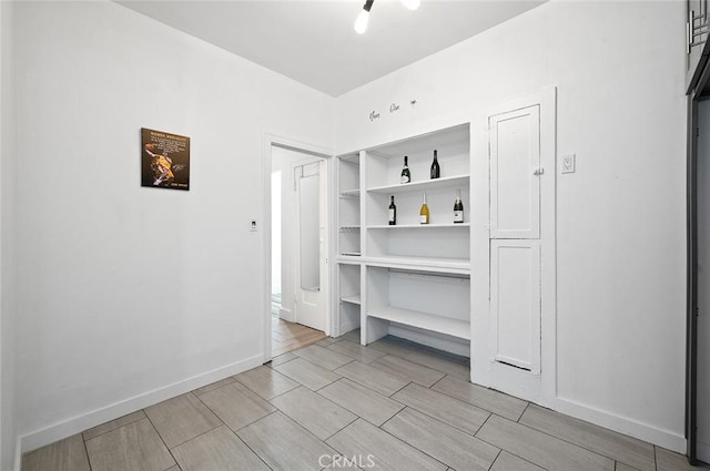 interior space featuring baseboards and wood tiled floor