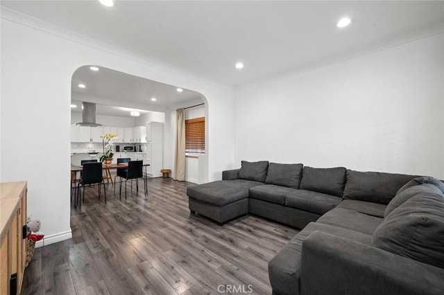 living area with arched walkways, baseboards, dark wood-style floors, and recessed lighting