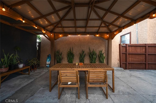 view of patio / terrace with fence, a gazebo, and outdoor dining space
